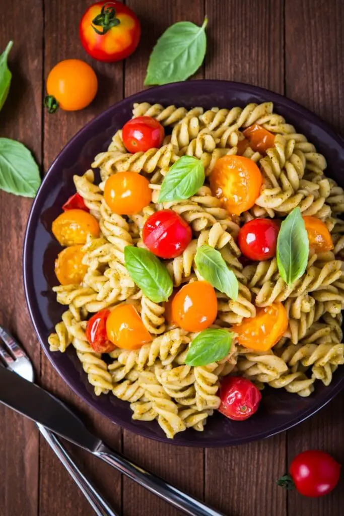 Hejmfarita pesto-pasta salato kun tomatoj kaj bazilio